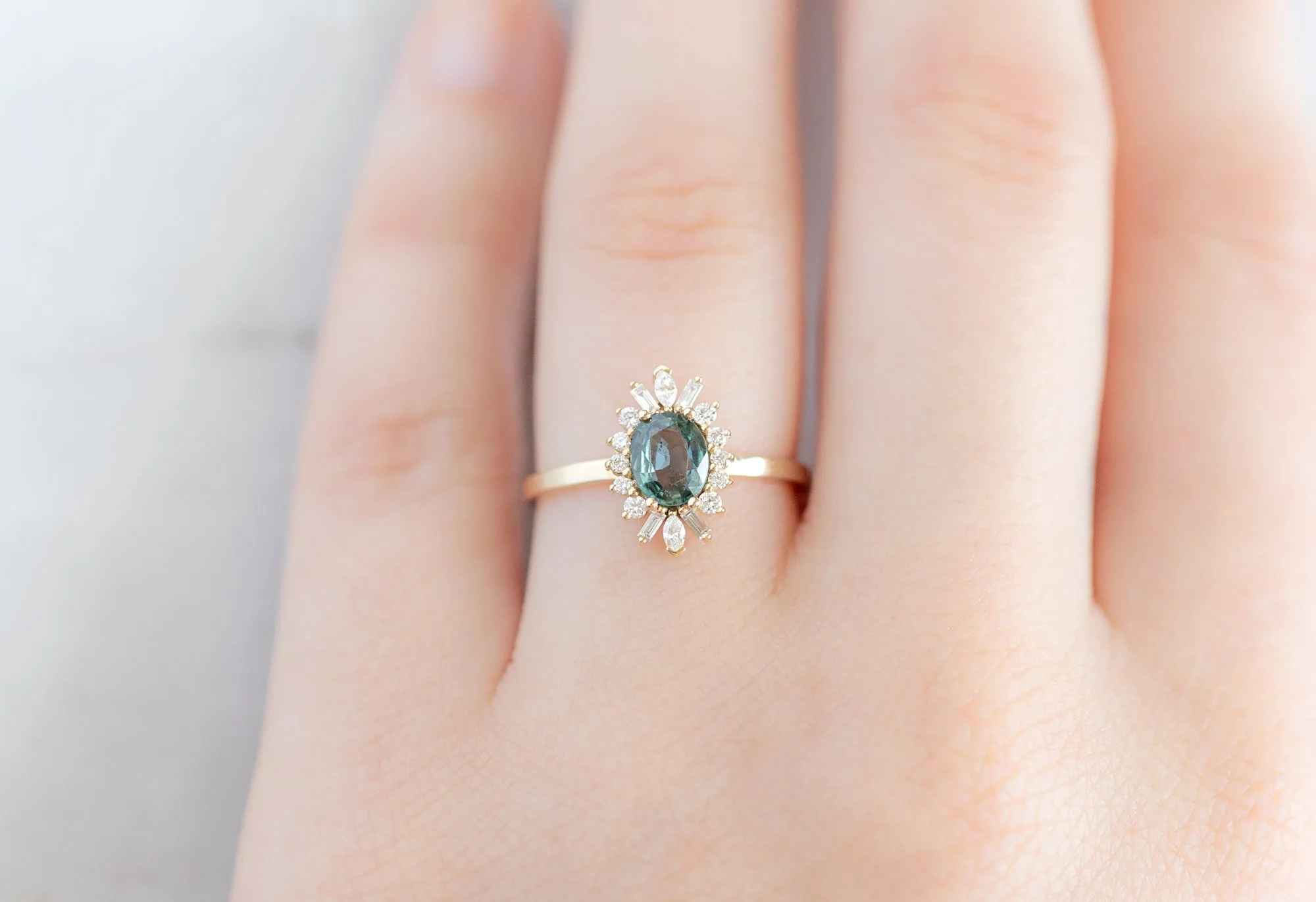 The Camellia Ring with a .72ct Oval-Cut Teal Sapphire